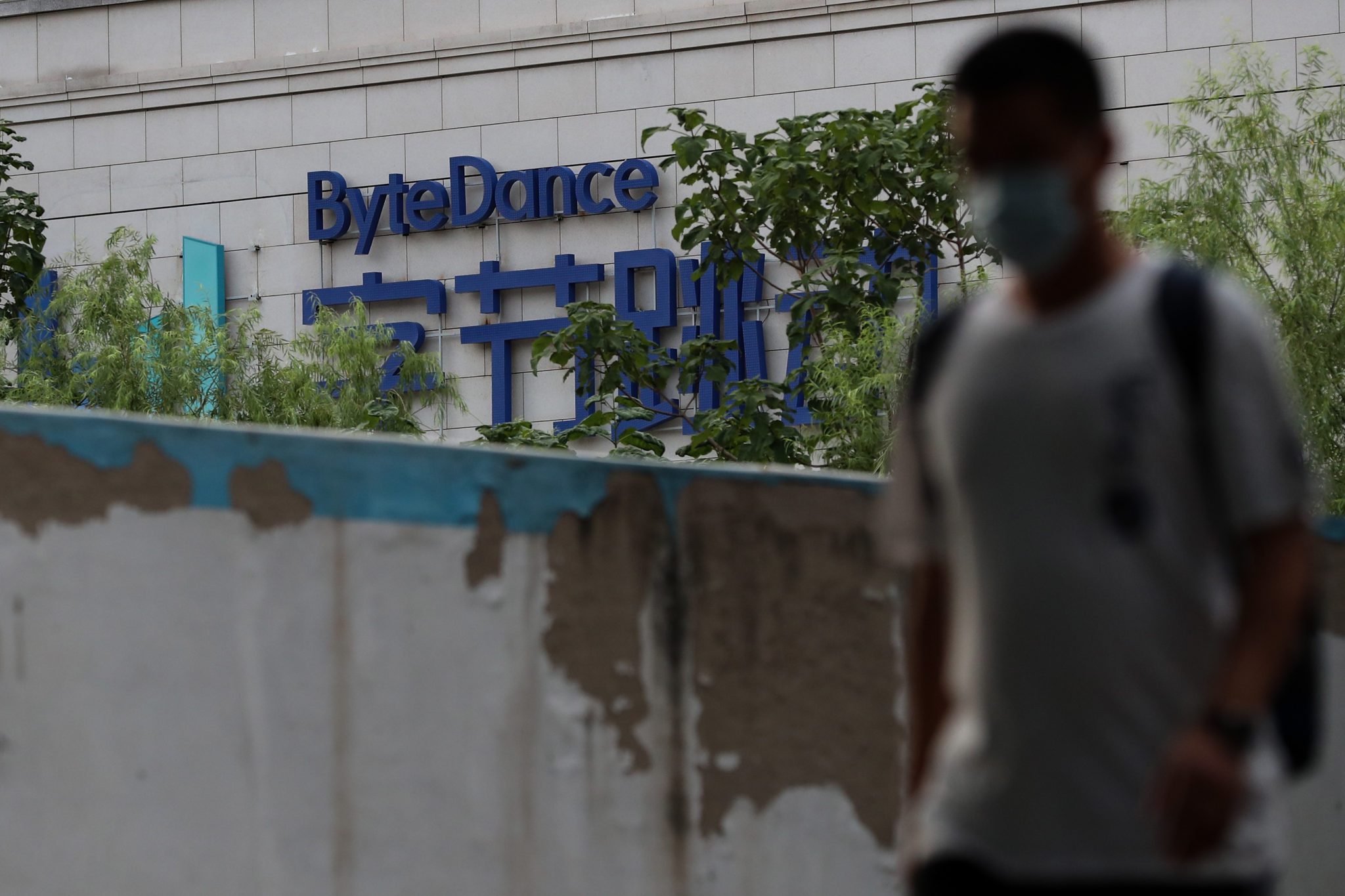 BEIJING, CHINA - AUGUST 04: A man wears protective mask as he walks past the ByteDance Ltd.'s office on August 04, 2020 in Beijing, China. TikTok is a Chinese video-sharing social networking service owned by a Beijing based internet technology company, ByteDance. The President of the United States Donald Trump is threatening and planning to ban the popular video sharing app TikTok from the US because of the security risk. Microsoft is interested in purchasing the TikTok platform in the United States. (Photo by Emmanuel Wong/Getty Images)
