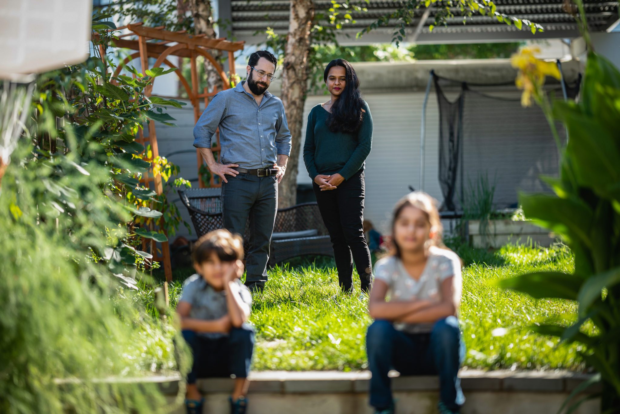 Eli Kasargod-Staub, and his wife Kavitha, watch over their children, aged 7 and 10, in the backyard of their home in Washington, D.C., on Tuesday, October 19, 2021. Photo by Cheriss May