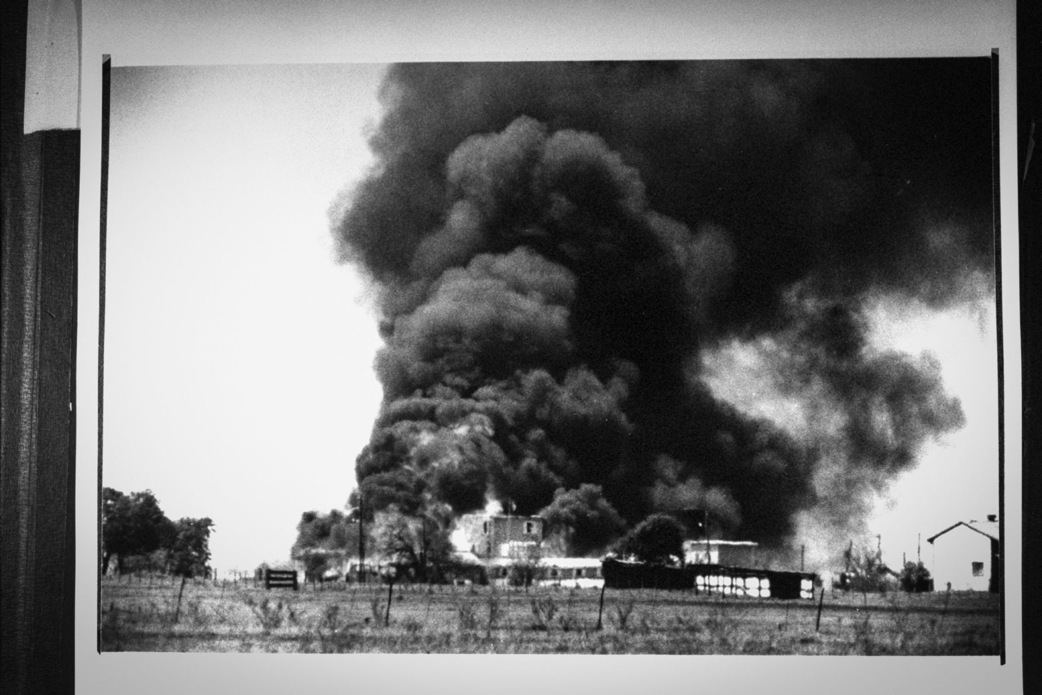 Smoking fire consuming David Koresh-led Branch Davidian cult compound; it remains unclear if the fire was started on the orders of Koresh or when tanks on loan to the FBI ripped holes in the compound & pumped tear gas in, hoping to end the 51-day siege.    (Photo by Mark Perlstein/Getty Images)