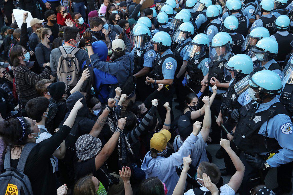 Police officers guarding the Trump International Hotel & Tower hold back protesters during a rally and march to remember the May 25 killing of George Floyd by a Minneapolis police officer, in the Loop Saturday, May 30, 2020, in Chicago, Ill. (John J. Kim/Chicago Tribune/Tribune News Service via Getty Images)
