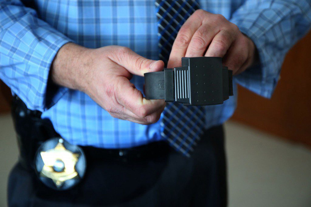 The director of the Cook County sheriff's electronic monitoring program, shows an electronic ankle bracelet on Feb. 5, 2015.